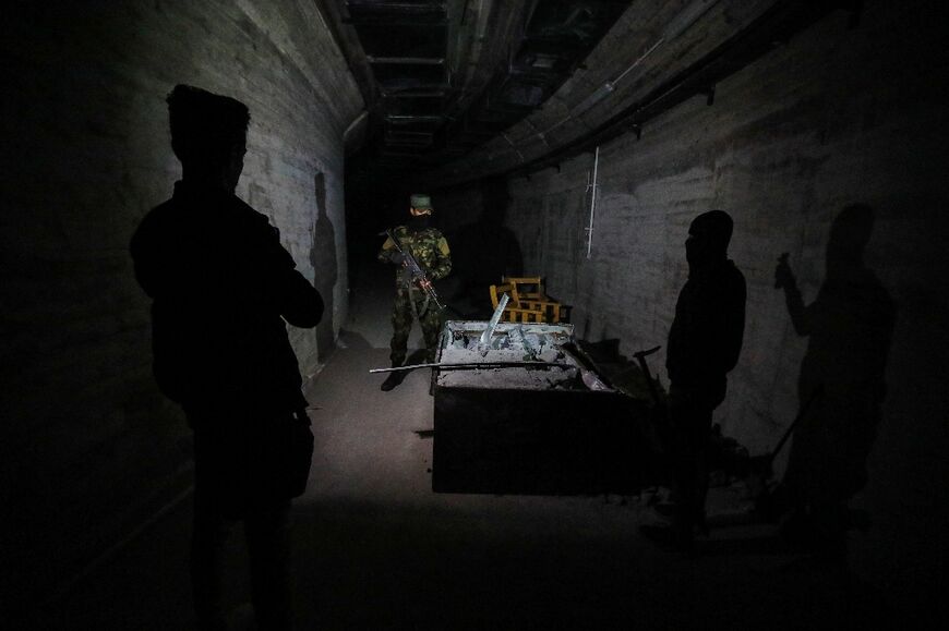 Syria security force members guard a tunnel in the complex from which ousted president Bashar al-Assad's feared younger brother Maher controlled his empire