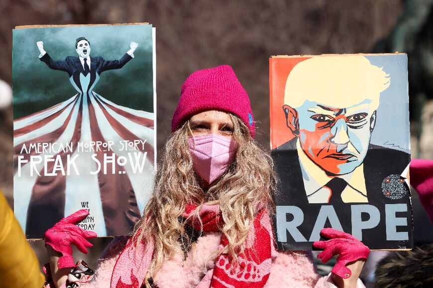 A protester in New York with a placard accusing US President Donald Trump of rape