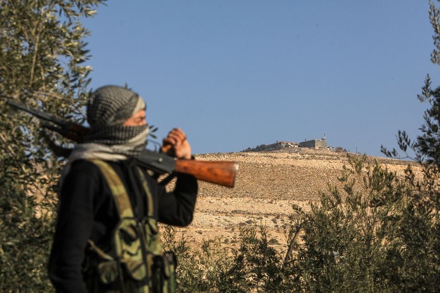 A guard watches over one of the feared Fourth Division bases on a hill overlooking Damascus 