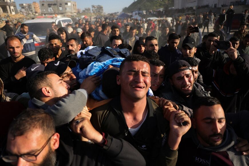 Relatives and colleagues carry the body of a slain journalist on a stretcher through the streets of Gaza