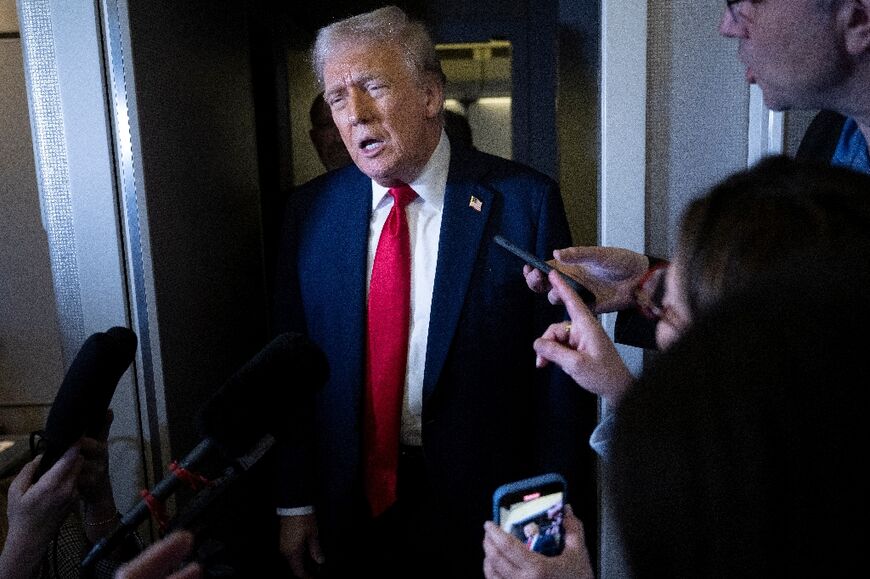 US President Donald Trump speaks to members of the press while returning to Washington, DC on Air Force One 