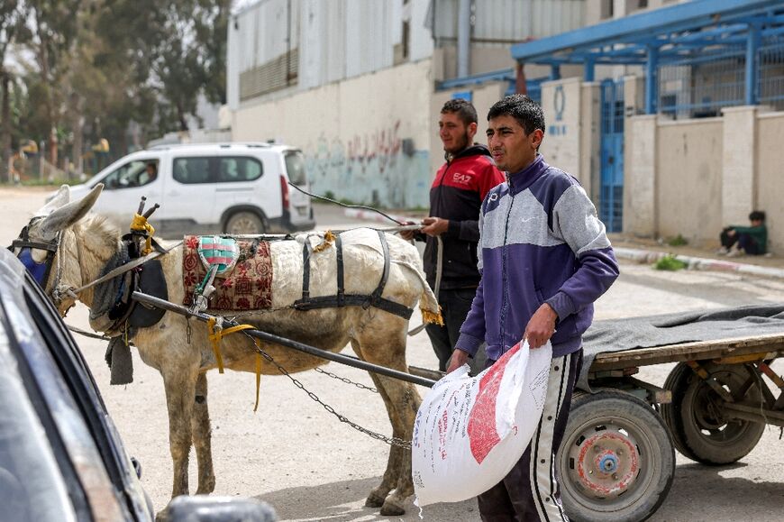 A man loads a sack of flour onto a donkey cart at a Gaza City aid distribution centre run by the UN agency for Palestinian refugees.