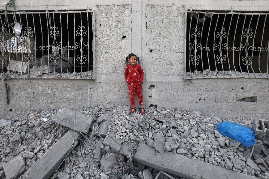 A crying Palestinian girl stands over the debris of a house hit by an Israeli strike in the south Gaza city of Khan Yunis on Wednesday.