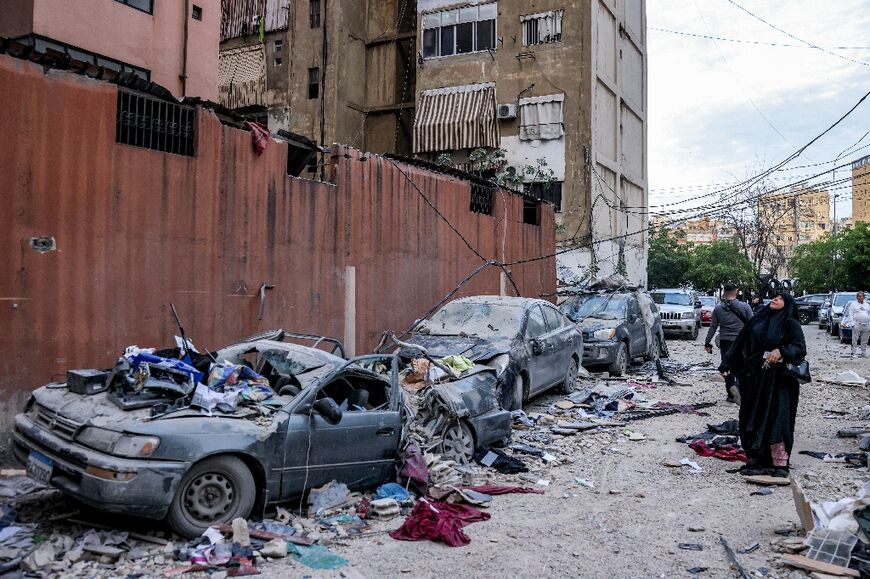 A woman looks up at a damaged building at the scene of an Israeli strike on a building in Beirut's southern suburbs on April 1, 2025