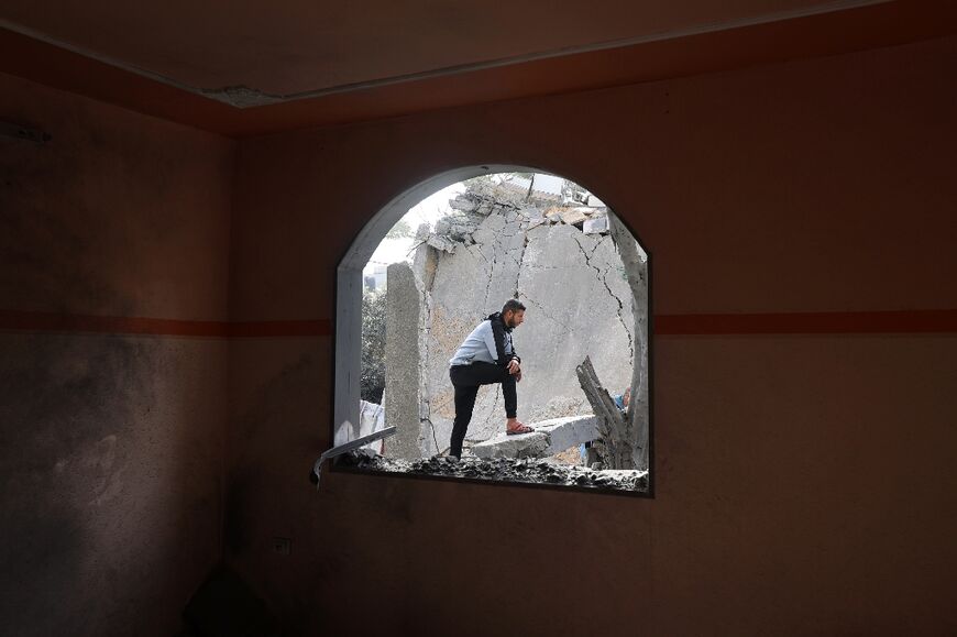 A Palestinian man stands on debris in a heavily damaged building following an overnight Israeli airstrike on a residential area in Deir al-Balah 