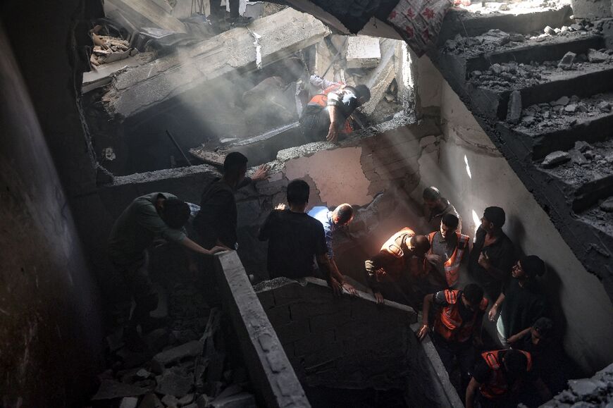 Residents and rescuers inside a building hit by an Israeli strike in Gaza City's Shujaiya district on April 10