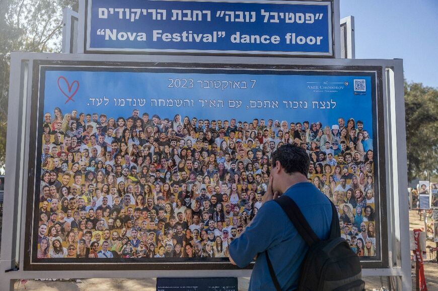 A man views a billboard depicting images of the Nova music festival victims