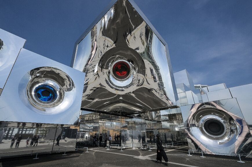 A woman (R) walks into the "null²" pavilion at the 2025 Osaka Expo