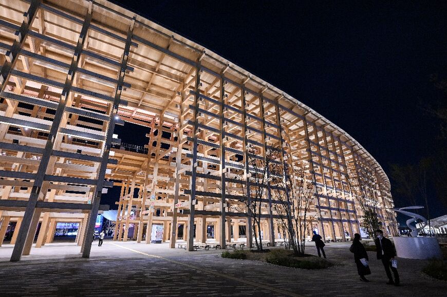 Visitors walk past the "Grand Ring", made of wood, at the venue for the 2025 Osaka Expo