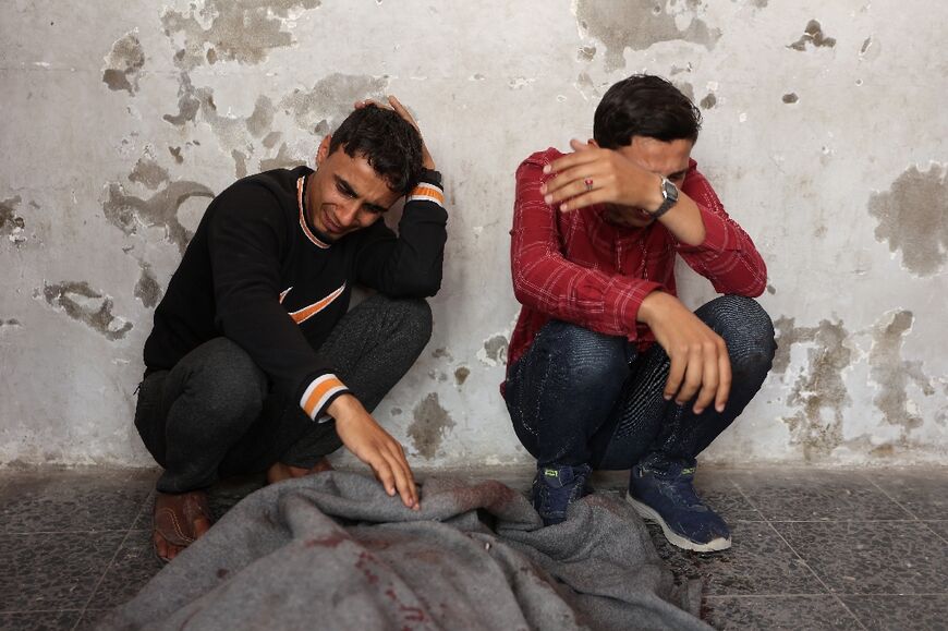 Palestinian men mourn at Gaza City's Al-Ahli Hospital after an Israeli strike on a school-turned-shelter killed 15 people in the Tuffah neighbourhood, the civil defence agency said.