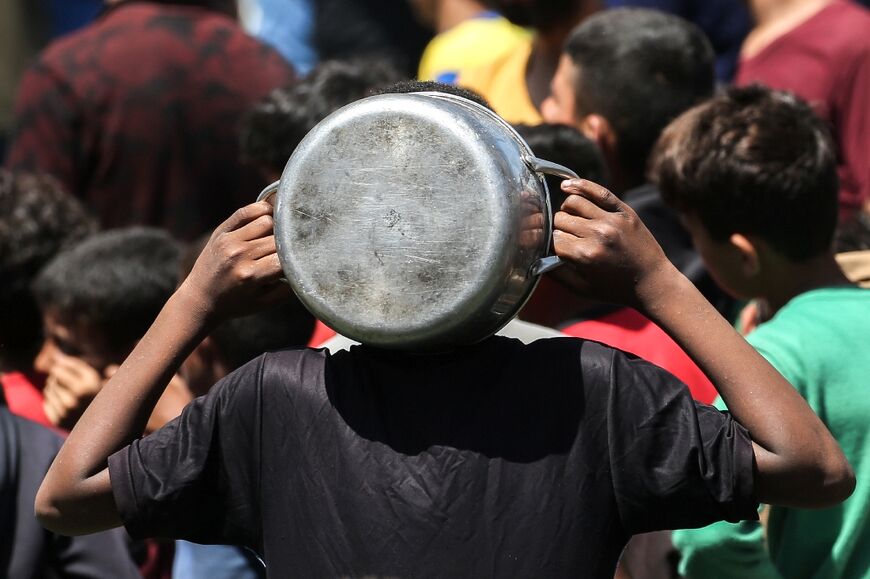Palestinians gather at a food kitchen in Nuseirat refugee camp in central Gaza.