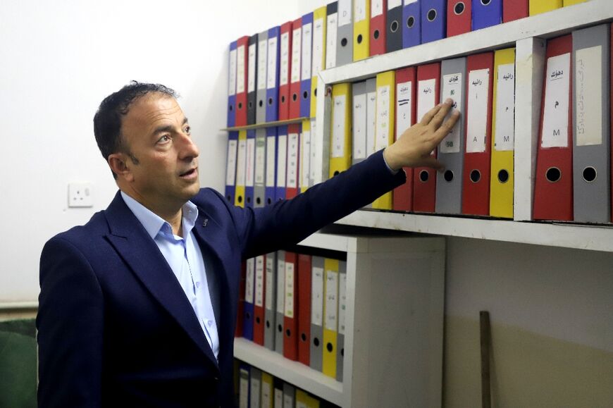 Abu Bakr Ali of the association for migrants returning from Europe with files of migrants believed to be missing or dead