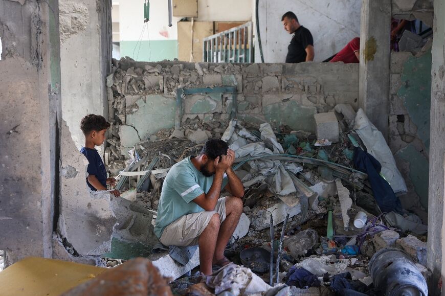 A man sits amid the rubble at the Fahmi Al-Jarjawi School in Gaza City