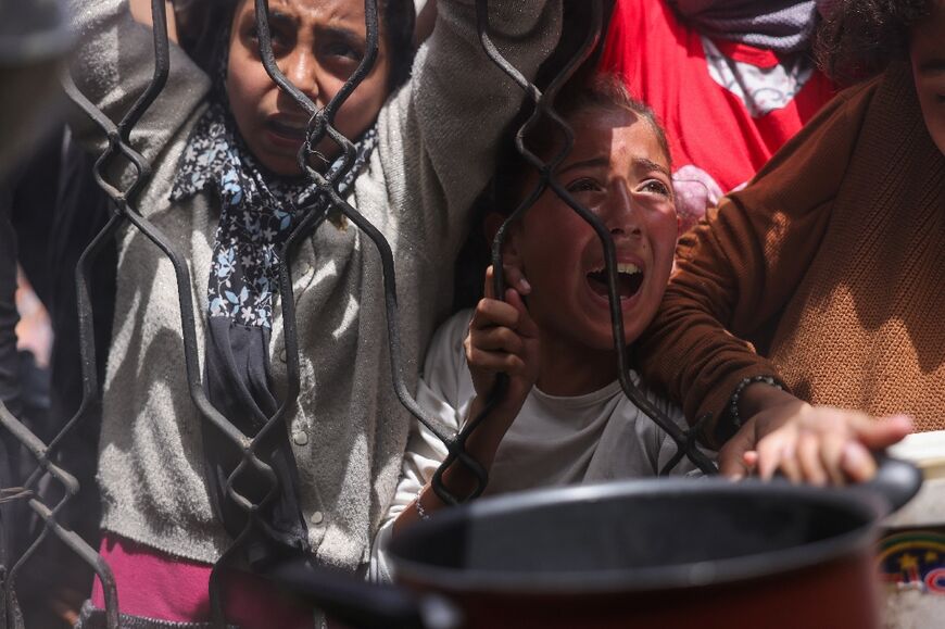 Palestinians wait for food from a charity kitchen in the northern Gaza Strip on Saturday amid an Israeli blockade on aid