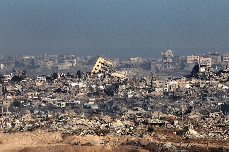 This picture taken from a position in southern Israel shows destroyed buildings in the Gaza Strip