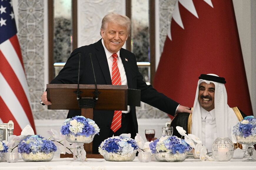 US President Donald Trump speaks with Qatar's Emir Sheikh Tamim bin Hamad al-Thani at the start of a state dinner at the Lusail Palace in Doha