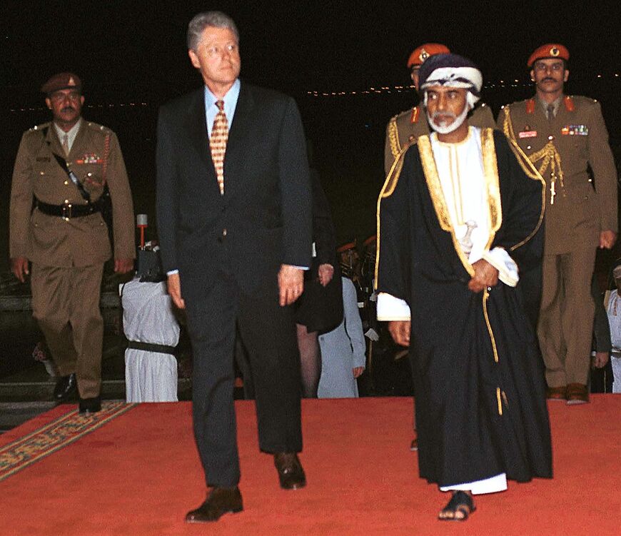 Sultan Qaboos of Oman escorts US President Bill Clinton upon his arrival 25 March 2000 to Oman airport. Clinton made a stopover in Oman on his way to Geneva for talks with Syrian President Hafez al-ssad on the Middle East peace process. (Photo by MOHAMMED MAHJOUB / AFP) (Photo by MOHAMMED MAHJOUB/AFP via Getty Images)