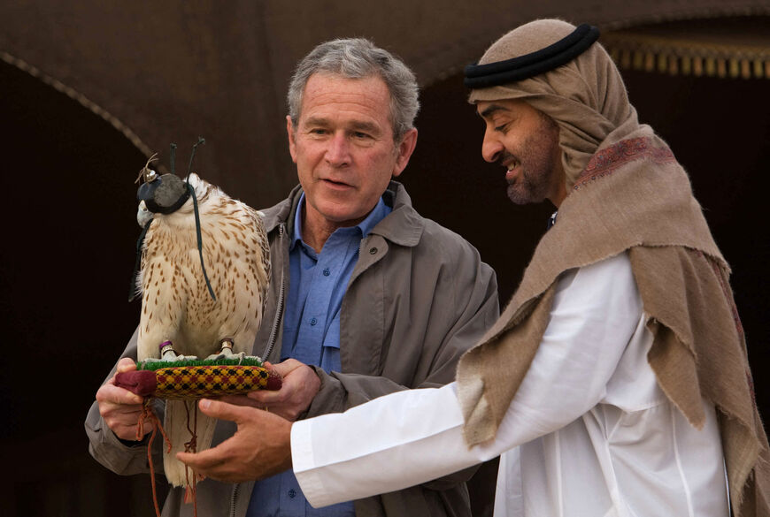 Abu Dhabi Crown Prince Sheikh Mohammed Bin Zayed al-Nahayan (R) looks on as US President George W. Bush holds a falcon at the the Royal Stables of the Al-Asayel Racing and Equestrian Club in Suwaihan, some 30 Kms outside Abu Dhabi, 13 January 2008 ahead of a dinner. Bush reached out to the Iranian people today in the keynote address of a Middle East tour, telling them they had a right to live under a government "that listens to your wishes". Person on the left is unidentified. AFP PHOTO/MANDEL NGAN (Photo b
