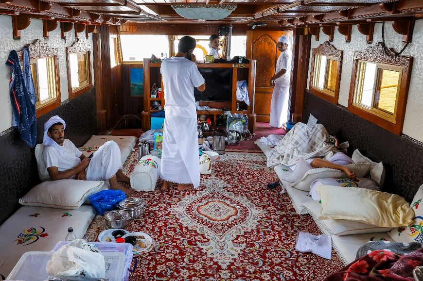Contestants in the line-fishing competition rest in the cabin of a wooden dhow.