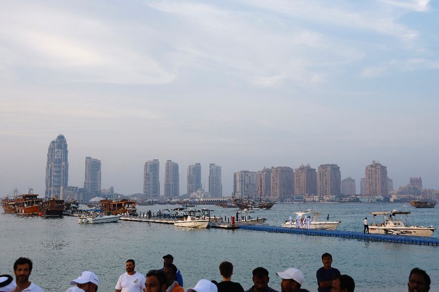 The high-rises of modern Doha dominate the skyline behind the fishing boat jetty where the festival is held.
