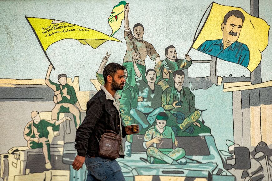 A mural in northern Syria showing Kurdish fighters with a flag bearing Ocalan's face