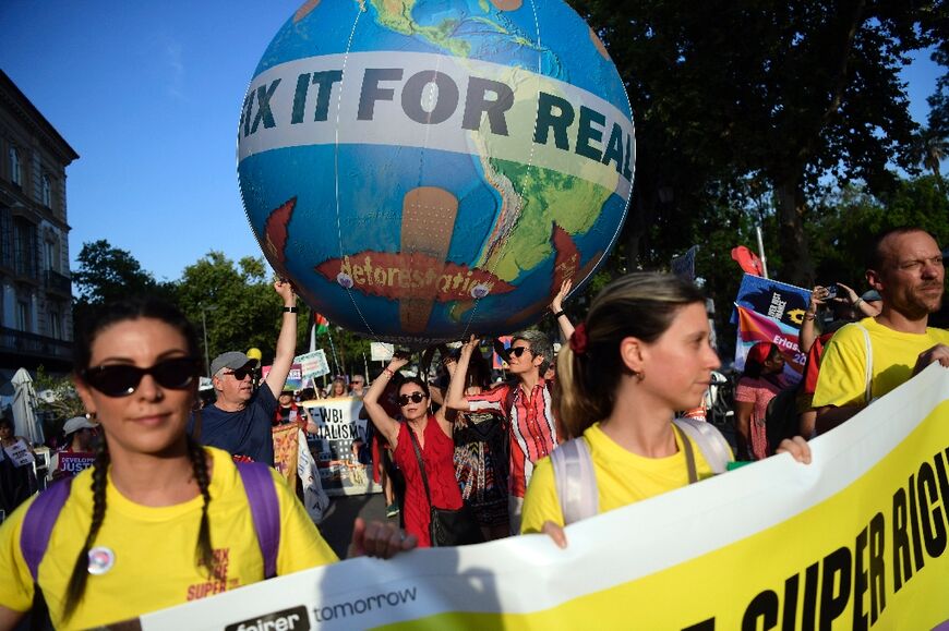 Hundreds of protesters demanded changes to global debt and tax norms in Seville on Sunday