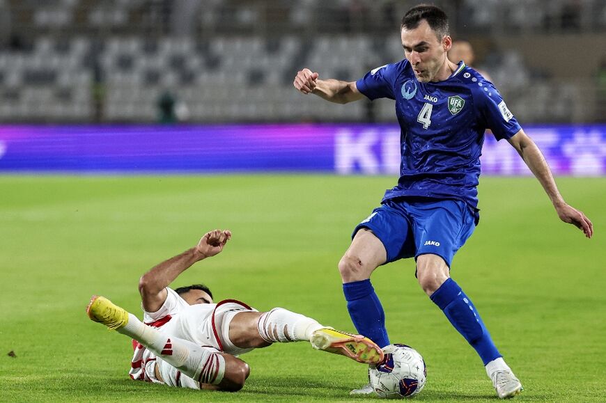Uzbekistan defender Farrukh Sayfiev (R) fights for the ball in the FIFA World Cup Asian Qualifier football match against the United Arab Emirates in Abu Dhabi