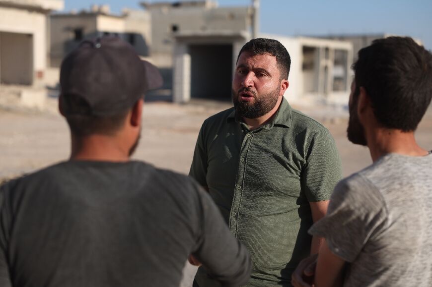 Syrian architect Abdel Aziz al-Mohammed (C) speaks to residents of his village Tal Mardikh