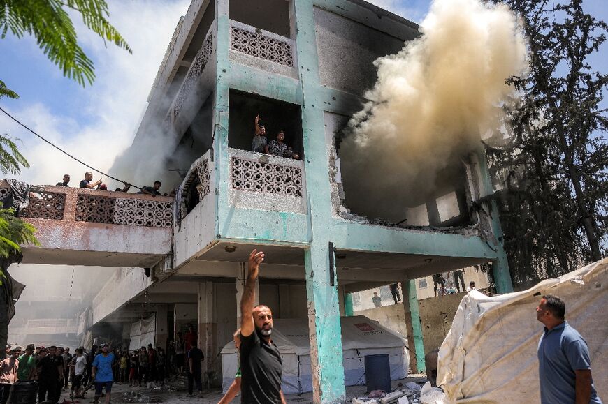 First-responders attempt to extinguish a blaze at Osama Bin Zaid school following an Israeli strike in the Saftawi district in western Jabalia 