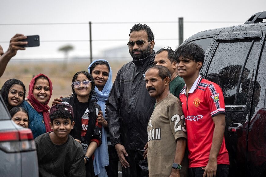 Happy rain chasers take selfies with "the Weatherman" after a successful expedition.
