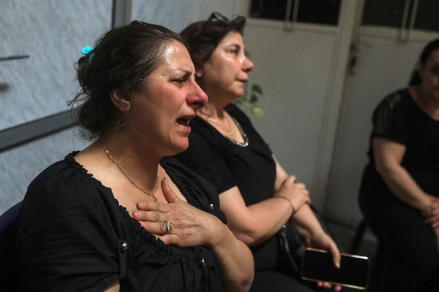 Relatives and friends mourn with members of the Bechara family who lost several members in the attack