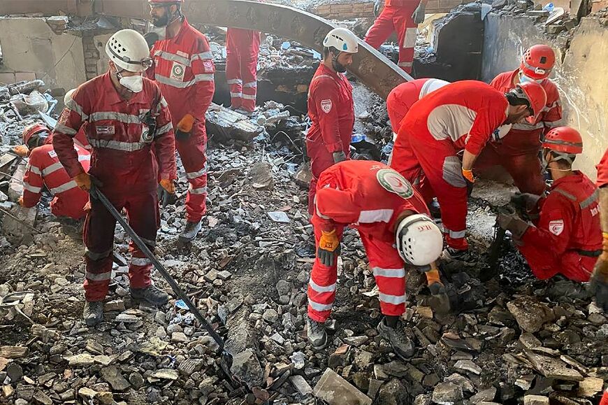 Iranian emergency services scour the rubble of a Tehran building for survivors after an Israeli air strike.