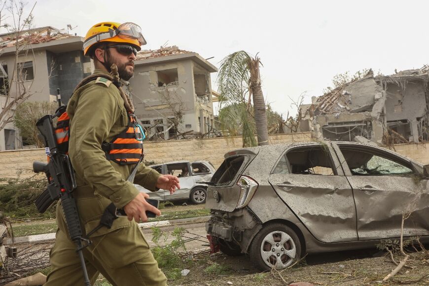 A member of the Israeli security forces rushes to the scene of an Iranian strike that hit Ness Ziona in central Israel