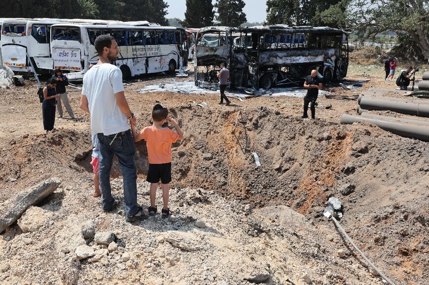 Israelis inspect the impact crater of a Iranian missile which struck a bus depot in Herzliya near Tel Aviv.
