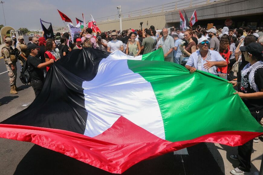 Supporters of Georges Ibrahim Abdallah holding a large Palestinian flag