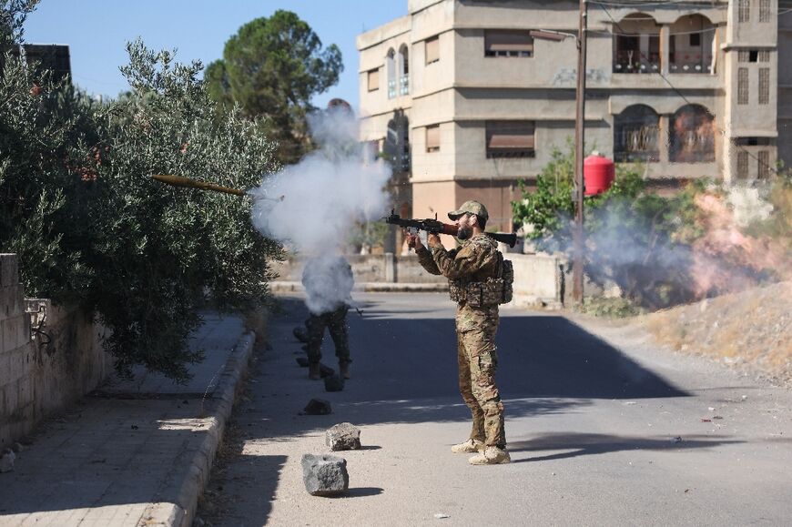 A Syrian government loyalist fires a shoulder-launched weapon in Sweida.