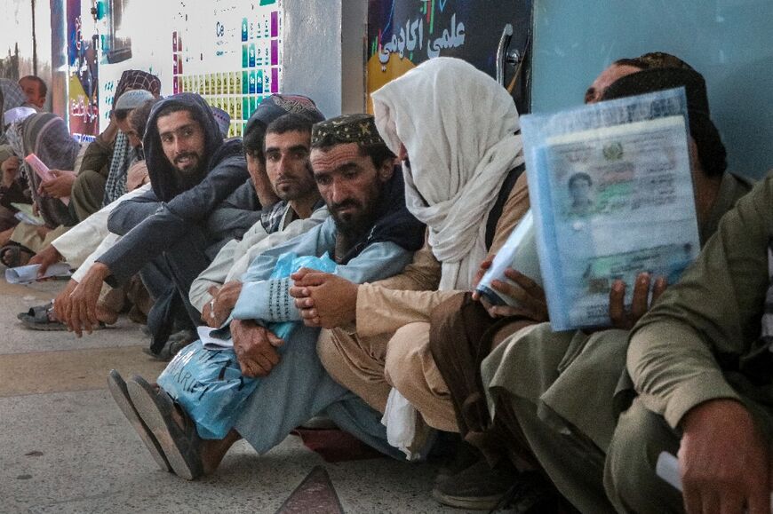 Afghan men wait in queues to submit their documents while applying for job vacancies in Qatar