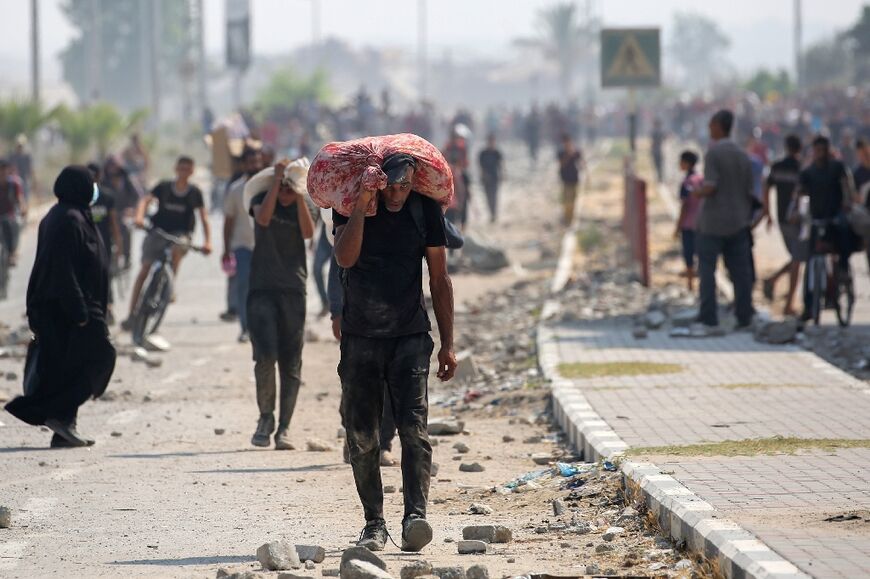 Palestinians return to Gaza's Nuseirat refugee camp with food parcels they have managed to obtain from an aid distribution point in the Israeli-controlled Netzarim Corridor.