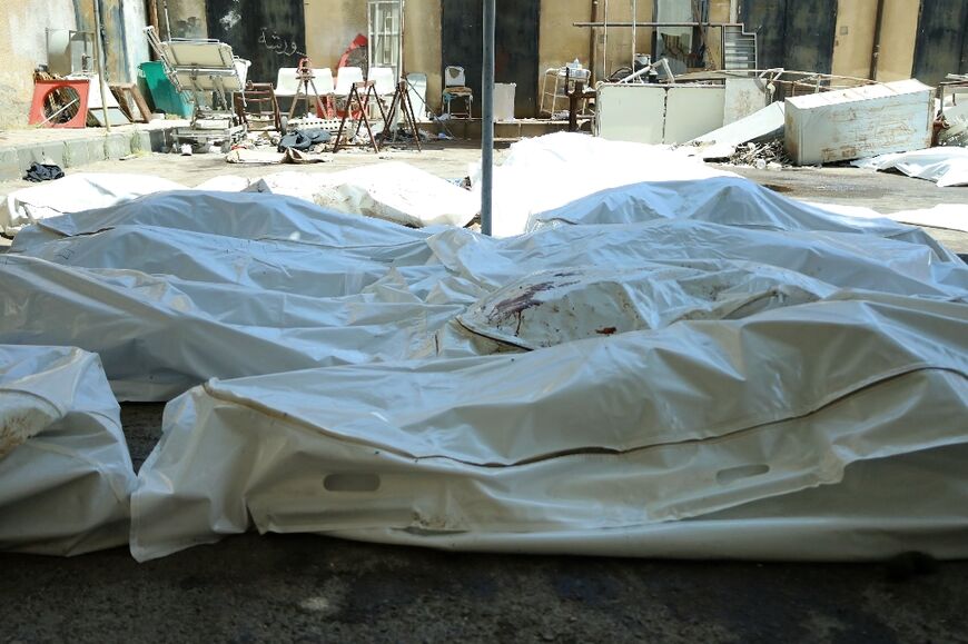 Unidentified bodies of people killed in sectarian violence in Syria's Sweida lie in bags outside the city's main hospital