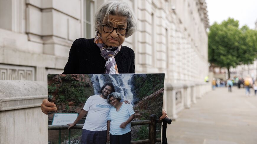 Laila Soueif, mother of activist Alaa Abd el-Fattah who is imprisoned in Egypt, holds a picture of herself and her son while continuing her hunger strike on May 28, 2025 outside Downing Street in London, England.
