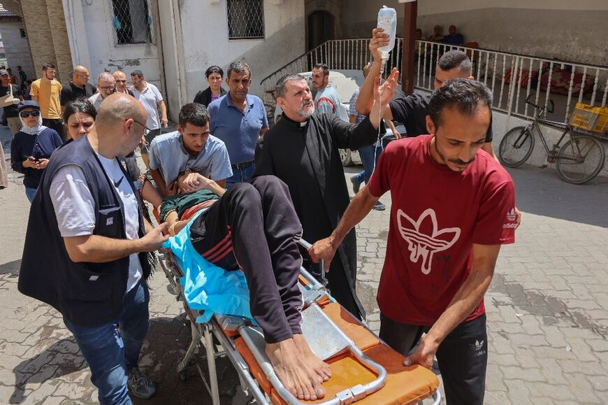 Palestinians who were injured in an Israeli strike on the Holy Family church receive treatment in Gaza City's Arab Ahli, also known as Baptist, hospital in Gaza City