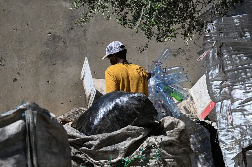 A plastic collector sorts through garbage in the working-class neighborhood of Bhar Lazreg near Tunis on July 10, 2025