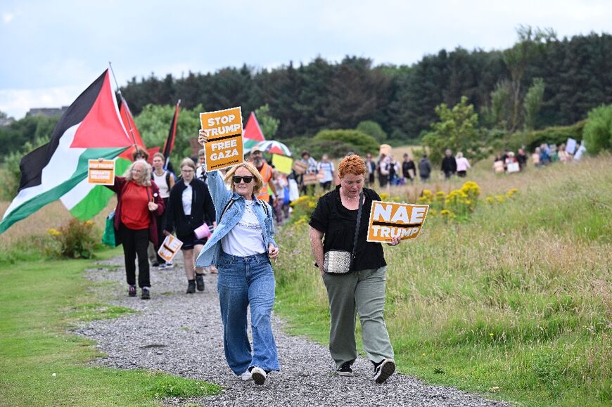 Anti-Trump protesters with their placards march down to the beach at Balmedie near Trump International Golf Links as Trump announced the US would set up food centres in Gaza