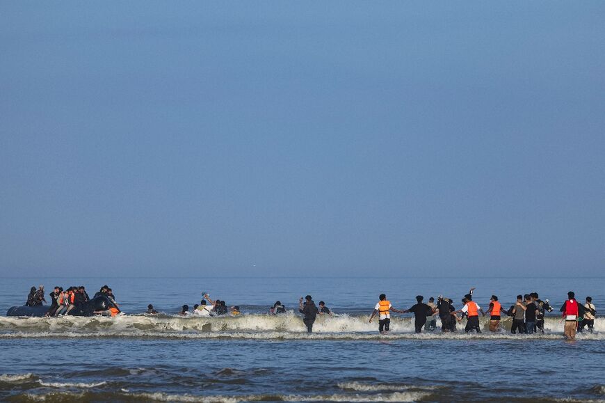 Migrants try to board a smuggler's boat to cross the Channel, from the beach of Equihen, northern France, on June 30, 2025