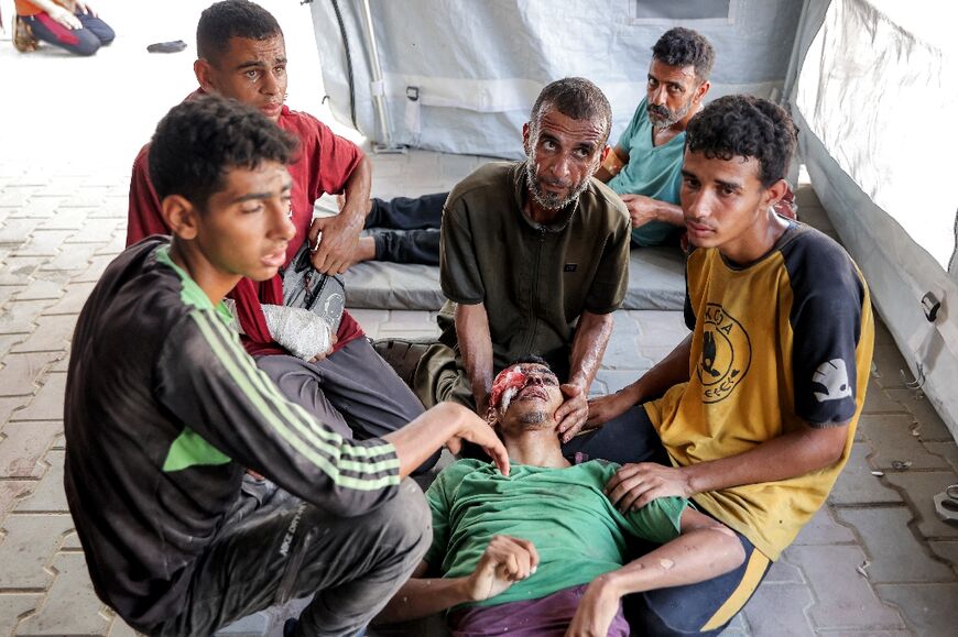 Men gathered around the body of a victim injured by gunfire while waiting for aid trucks in Gaza on July 27