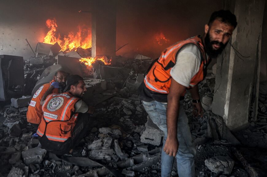 Palestinian civil defence workers tried to extinguish a fire at a building hit by an Israeli strike in Gaza City