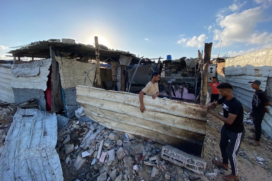 Palestinians recover what they can from the debris of an Israeli strike on the makeshift camp in Mawasi.