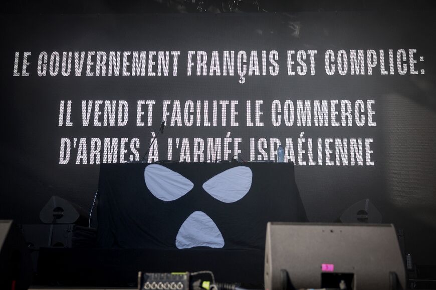 During the show, Kneecap displayed a backdrop accusing the French government of facilitating the sale of weapons to Israel
