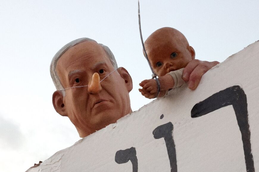 Israeli Prime Minister Benjamin Netanyahu, seen here as a caricature at a protest in Tel Aviv, is under mounting domestic and international political pressure 