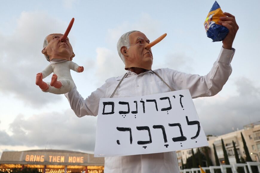Israeli Prime Minister Benjamin Netanyahu, seen here as a caricature during a protest in Tel Aviv, is under increasing domestic and international pressure to resolve the conflict